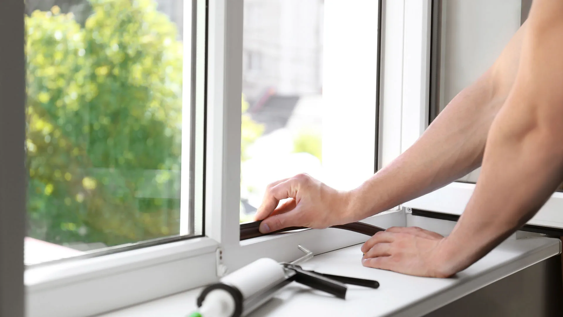 Construction professional sealing a residential window frame